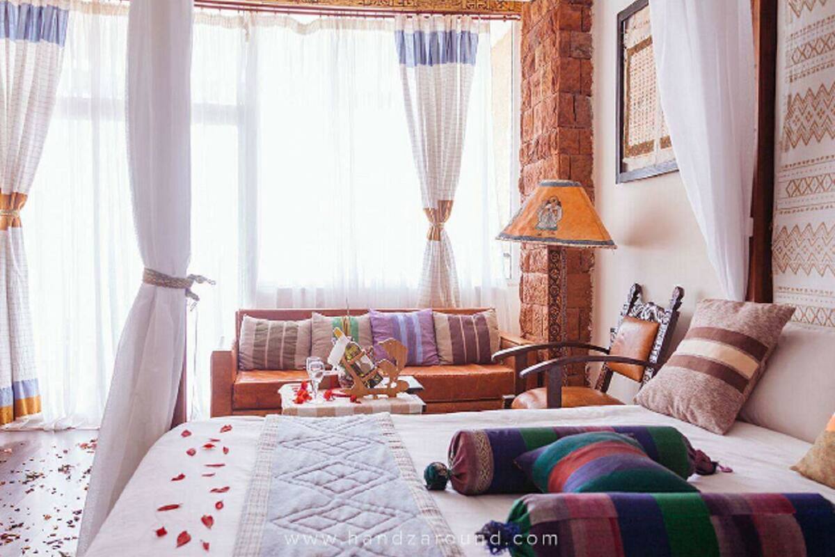 Un dormitorio acogedor con cama, sofá, sillón y lámpara.