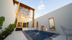 Una casa moderna con piscina, ventanas amplias y diseño minimalista.