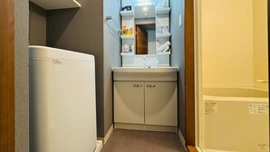 A compact bathroom with a white sink, mirror, and storage cabinets. - New! LuxurySweet Hakata Ekiminami 52 ・Max 3~4 people, 5 min. drive from Hakata Station, New construction (Fukuoka Hakata Ward)