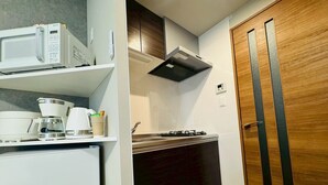 A compact kitchenette with a microwave, coffee maker, and gas stove. - New! LuxurySweet Hakata Ekiminami 52 ・Max 3~4 people, 5 min. drive from Hakata Station, New construction (Fukuoka Hakata Ward)