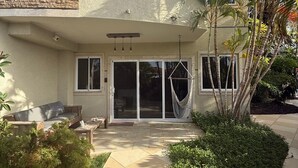 A residential building with a patio area, a hammock, and a palm tree. - Luxury Townhouse 6 Minutes from Beach & Casino (Oranjestad)