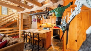 Ein Holzblock-Interieur mit Küche, Essbereich und einer Treppe.