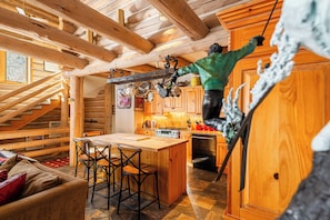 A wooden cabin interior with a kitchen, dining area, and a staircase. - Experience luxury at Deer Valley Pine Inn 4, a ski-in/ski-out townhome in Park City. (Park City)