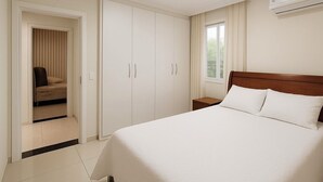 Quarto com cama, guarda-roupa, mesa de cabeceira e janela.