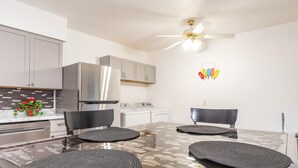 Una cucina moderna con isola centrale, elettrodomestici in acciaio inossidabile e ventilatore a soffitto.