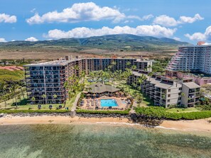 Ein Resort mit mehreren Hochhäusern, einem zentralen Poolbereich und einem Strand.