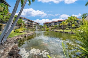 A hotel with a koi pond, palm trees, and a clear sky. - SUMMER SALE! Ocean view 2BR condo in West Maui, perfect for groups of 6- PK L106 (Lahaina)