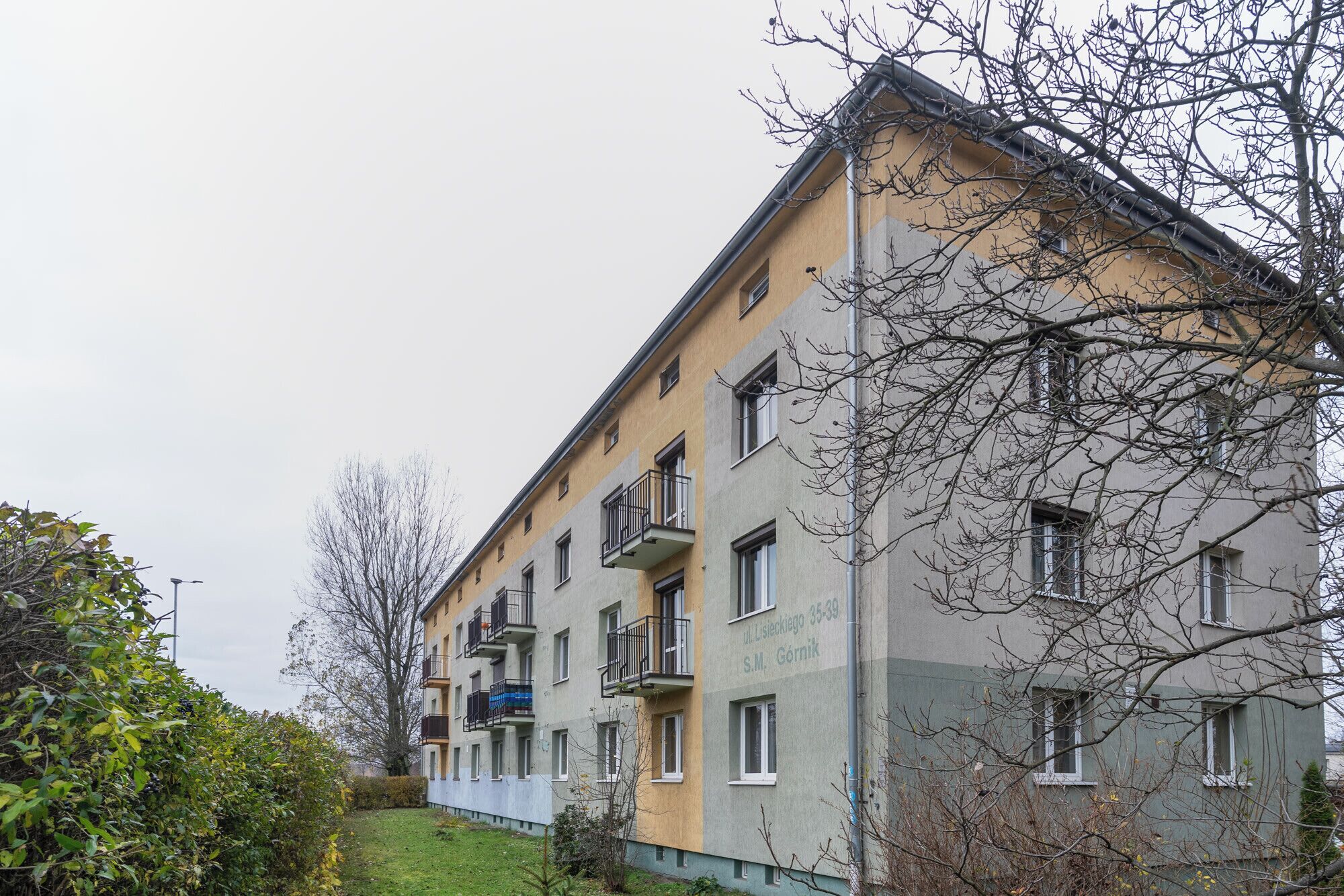 A multi-story residential building with balconies and a flat roof.