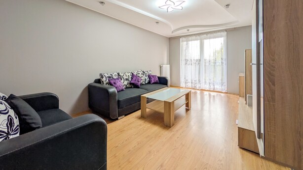 Ein modernes Wohnzimmer mit einer Couch, einem Couchtisch und Holzboden.