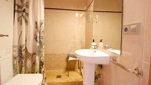 A bathroom with a toilet, sink, and shower.