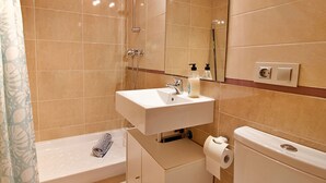 A bathroom with a sink, toilet, and shower.