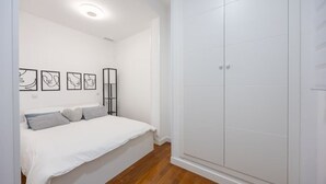Un dormitorio con cama, armario y decoración en la pared.
