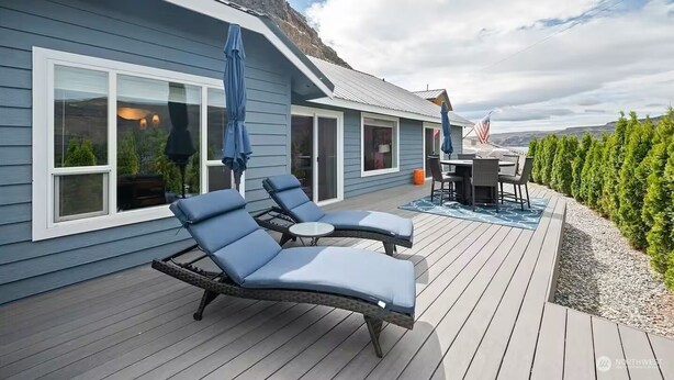 Une terrasse avec des chaises longues, une table et un drapeau américain.
