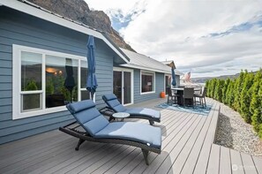 Una terraza con sillones de descanso, una mesa y una bandera estadounidense.