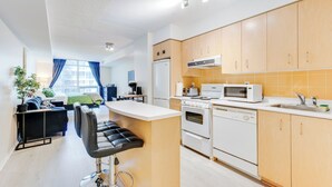 Une cuisine moderne avec des meubles en bois, un îlot central et un coin repas comprenant un canapé et des chaises noirs.