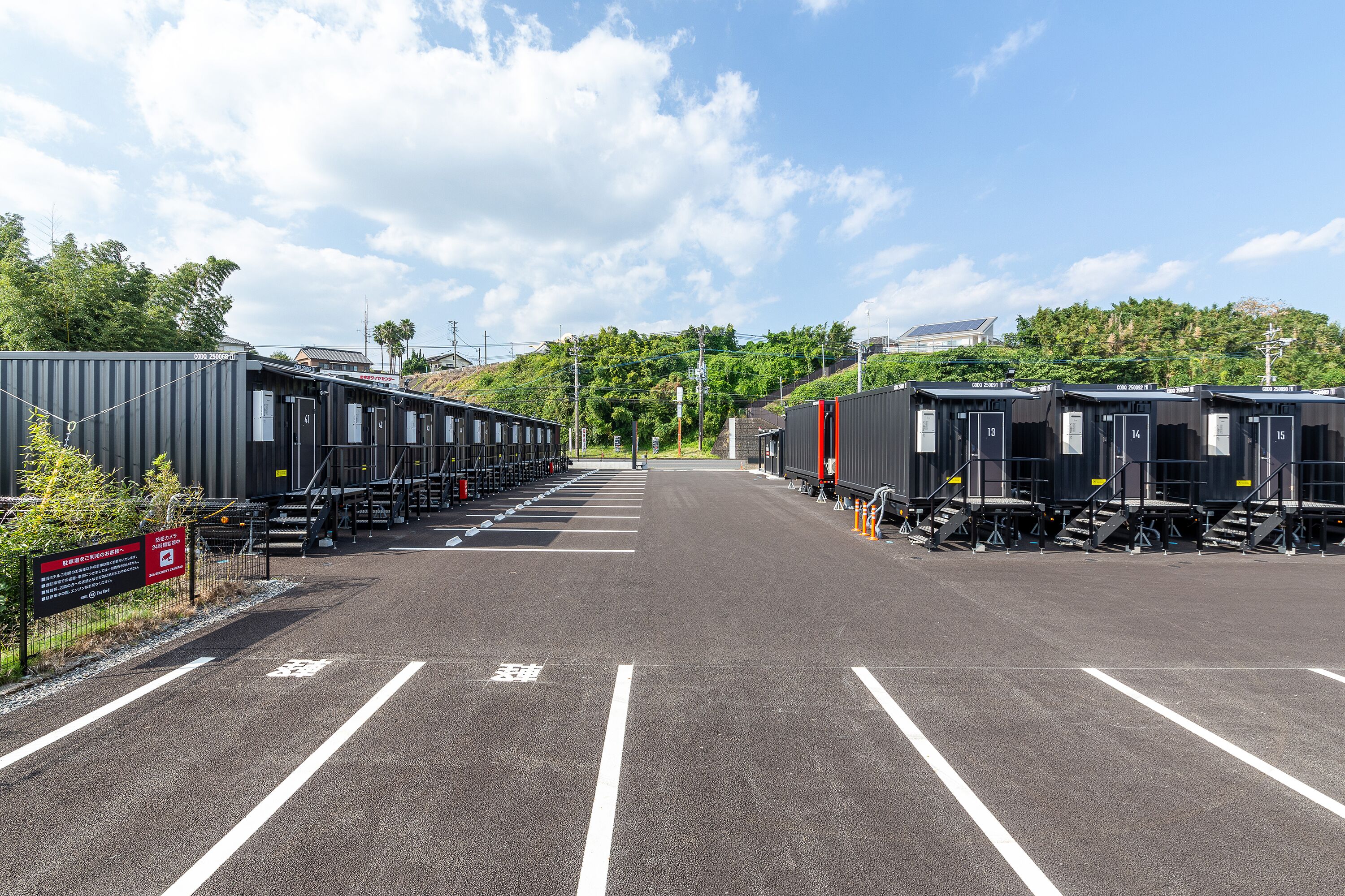 A parking lot with rows of train carriages and a building in the background.