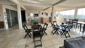 A spacious dining area with high ceilings and large windows, featuring multiple tables and chairs. - Pousada Rancho do Sabiá (Baraúna)
