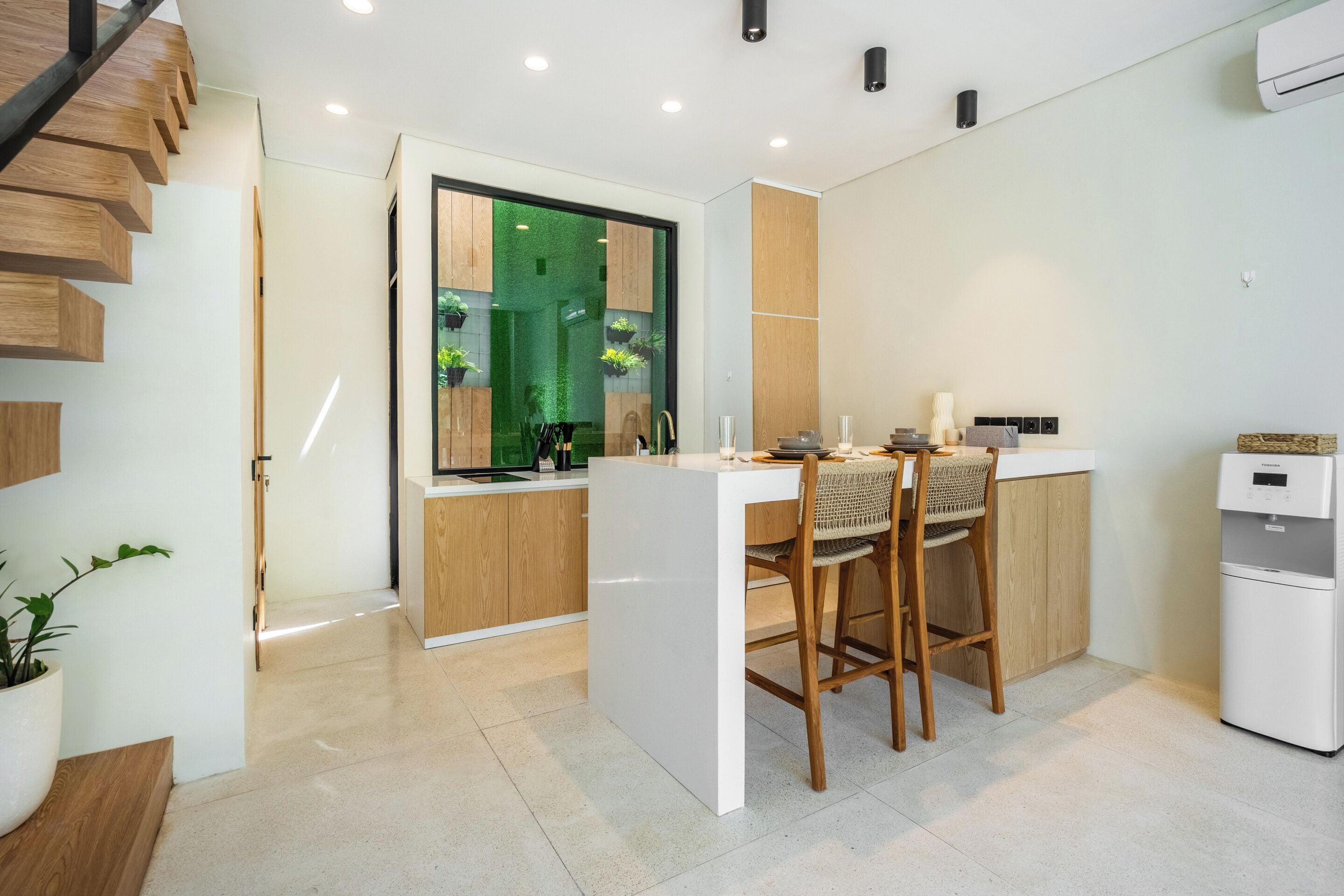 A modern kitchen with a central island, wooden cabinets, and a built-in stove.