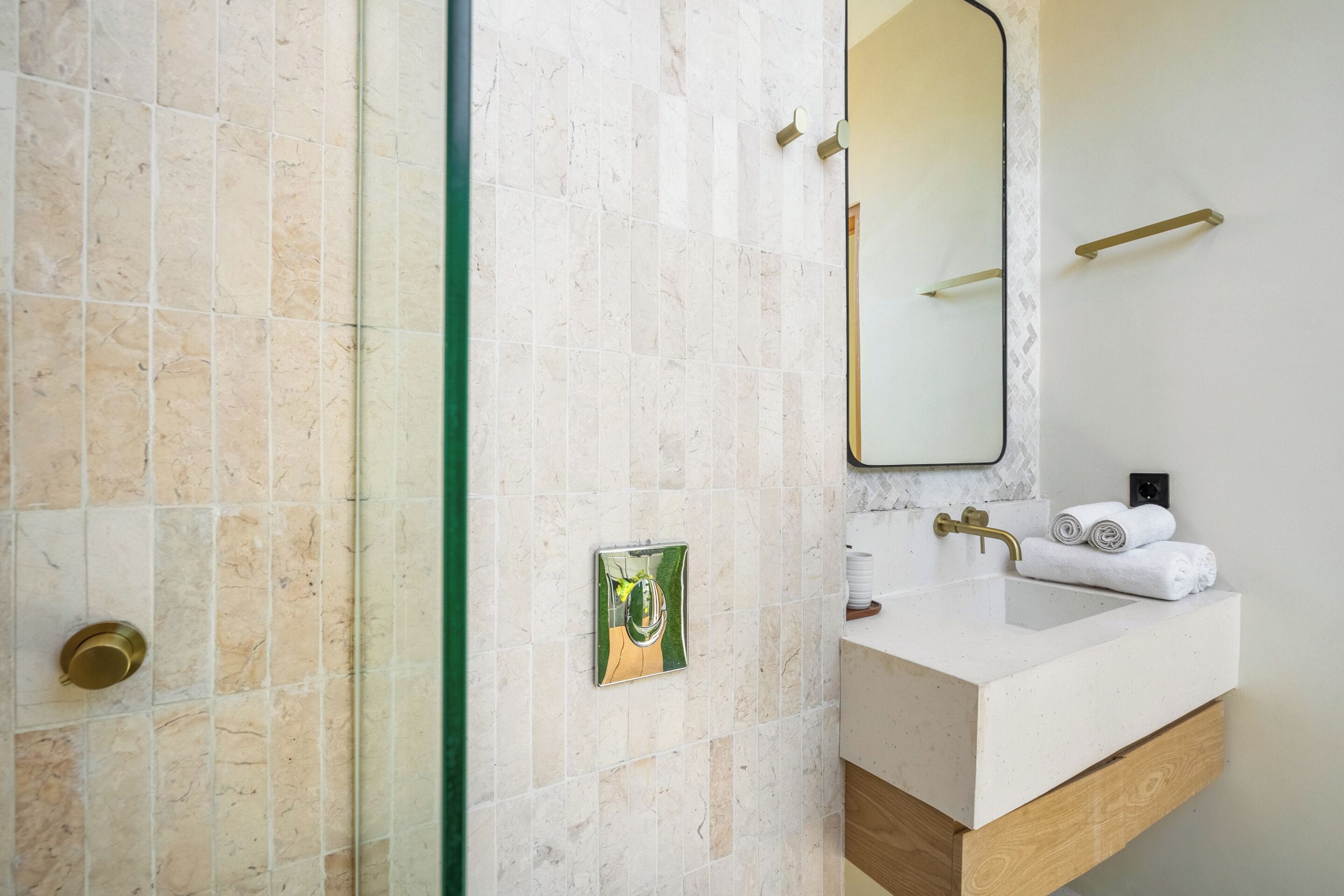 Un bagno con lavandino bianco, uno specchio e un porta asciugamani.
