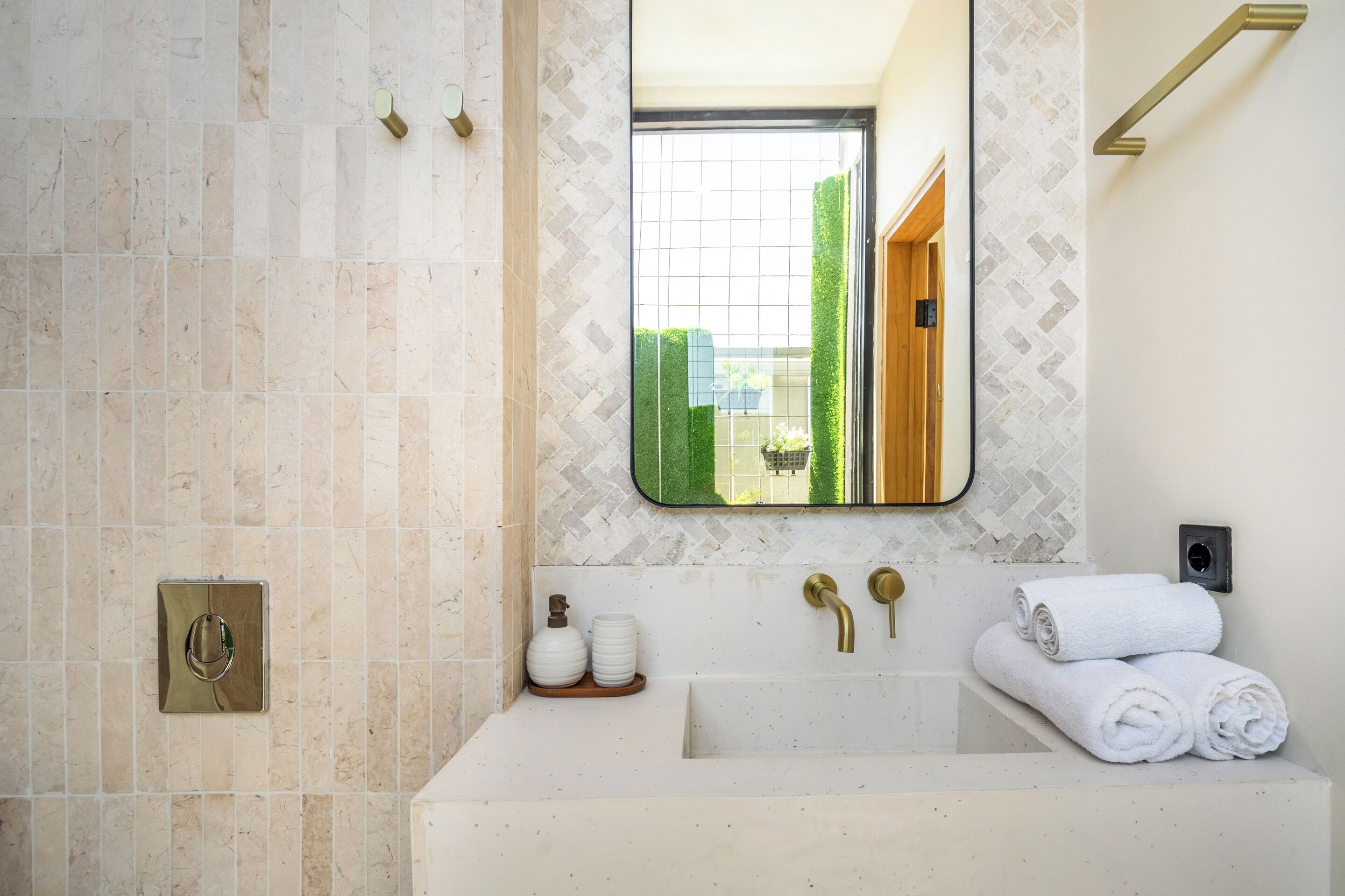 A bathroom with a large mirror, a bathtub, and a sink.
