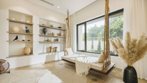 A modern room with a hanging swing, a large window, and shelves with decorative items. - Velia Villa Sóc Sơn (Hanoi)