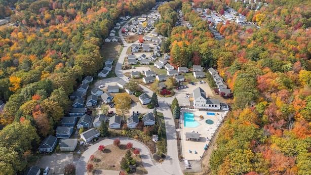 Vue aérienne d’un quartier résidentiel avec des maisons, une piscine et une allée circulaire.