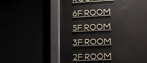 Un directorio de habitaciones de hotel con números y nombres, incluyendo Rooftop, Habitación 6F, Habitación 5F, Habitación 3F, Habitación 2F, Salón 1F y Lavandería B1.