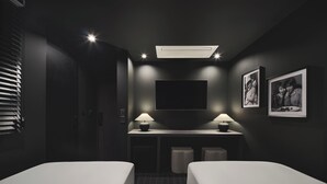 A hotel room with two single beds, a desk with two lamps, a flat-screen TV mounted on the wall, and a ceiling light fixture. - Guwol Hotel Jongno Ikseon (Seoul)