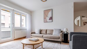 Ein Wohnzimmer mit einer Couch, einem Couchtisch, einer Lampe und einem Bild an der Wand.
