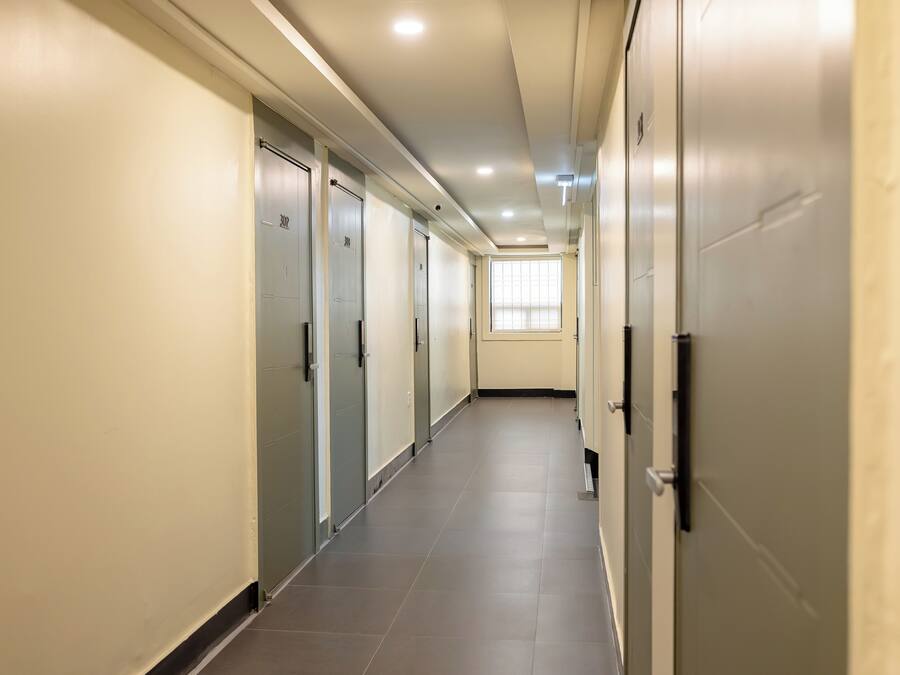 A long, narrow hallway with doors on both sides, leading to individual rooms.