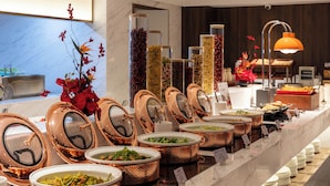 A buffet with multiple copper serving dishes, a variety of food options, and a modern interior design. - Kaiyuan Mingting Hotel (Chengdu)