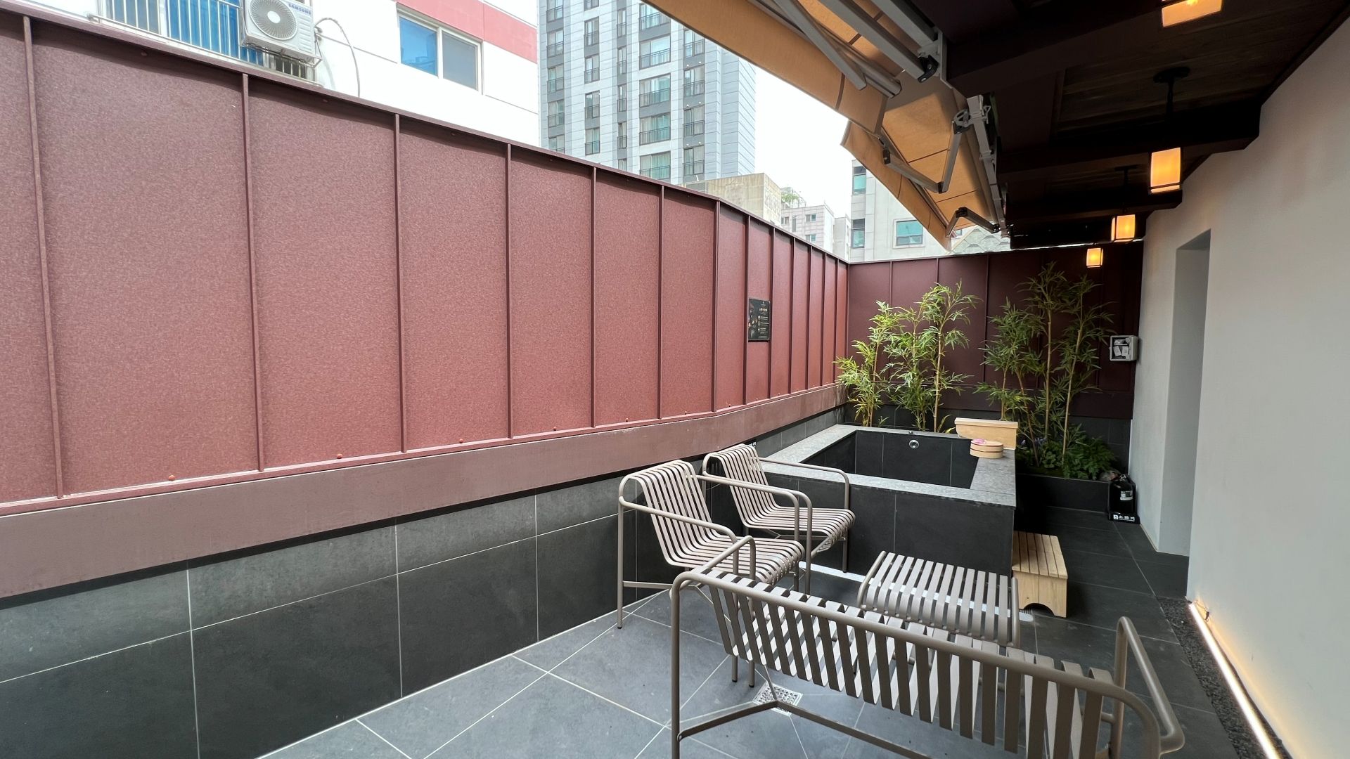 Terraço no telhado com área de estar, banheira de hidromassagem e vista para a paisagem urbana.