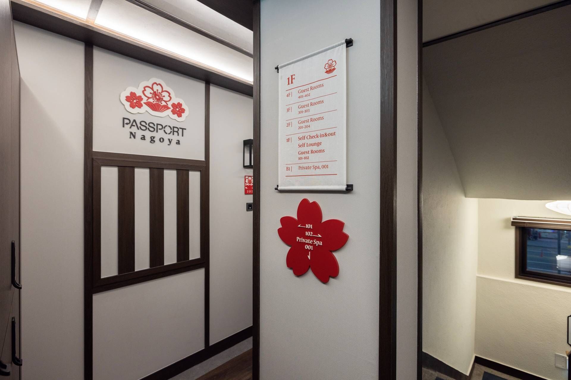 A hallway with a sign for Passport Nagoya, a self-check-in/out area, and a private spa.