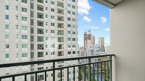 A high-rise building with multiple balconies and a view of a river and other buildings. - Javen by Kozystay - Thamrin (Jakarta)