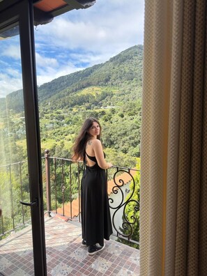 Un balcón con vistas a una ladera verde.