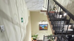 Eine Treppe mit Geländer, Blumentöpfen und einem Bild an der Wand.