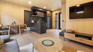 A modern living space with a kitchen, dining area, and seating area.