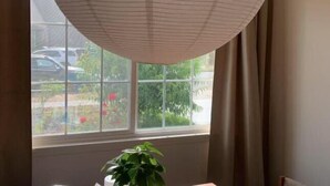 A room with a large window, a ceiling fan, and a potted plant. - SUNNY HOME (Alhambra)