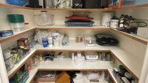 A well-organized kitchen with various appliances, including a coffee maker, blender, and toaster. There are also shelves with dishes and kitchen utensils. -  Beautiful  home with 4 community areas and 5 bedrooms. (Indianapolis)