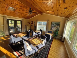A dining area with wooden ceiling beams, a ceiling fan, and large windows with curtains. -  Beautiful  home with 4 community areas and 5 bedrooms. (Indianapolis)