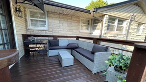 An outdoor deck with a wicker sofa, a small table, and chairs. -  Beautiful  home with 4 community areas and 5 bedrooms. (Indianapolis)