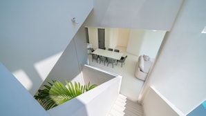 Ein modernes Interieur mit Essbereich, Treppe und einer Pflanze.