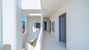 Ein moderner, weiß gestrichener Innenbereich mit einer Treppe, die zu einer oberen Ebene führt.