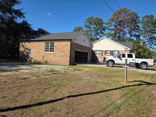 A two-story house with a garage, a driveway, and a white pickup truck parked in front. - Large Desirable Corner House (Loris)
