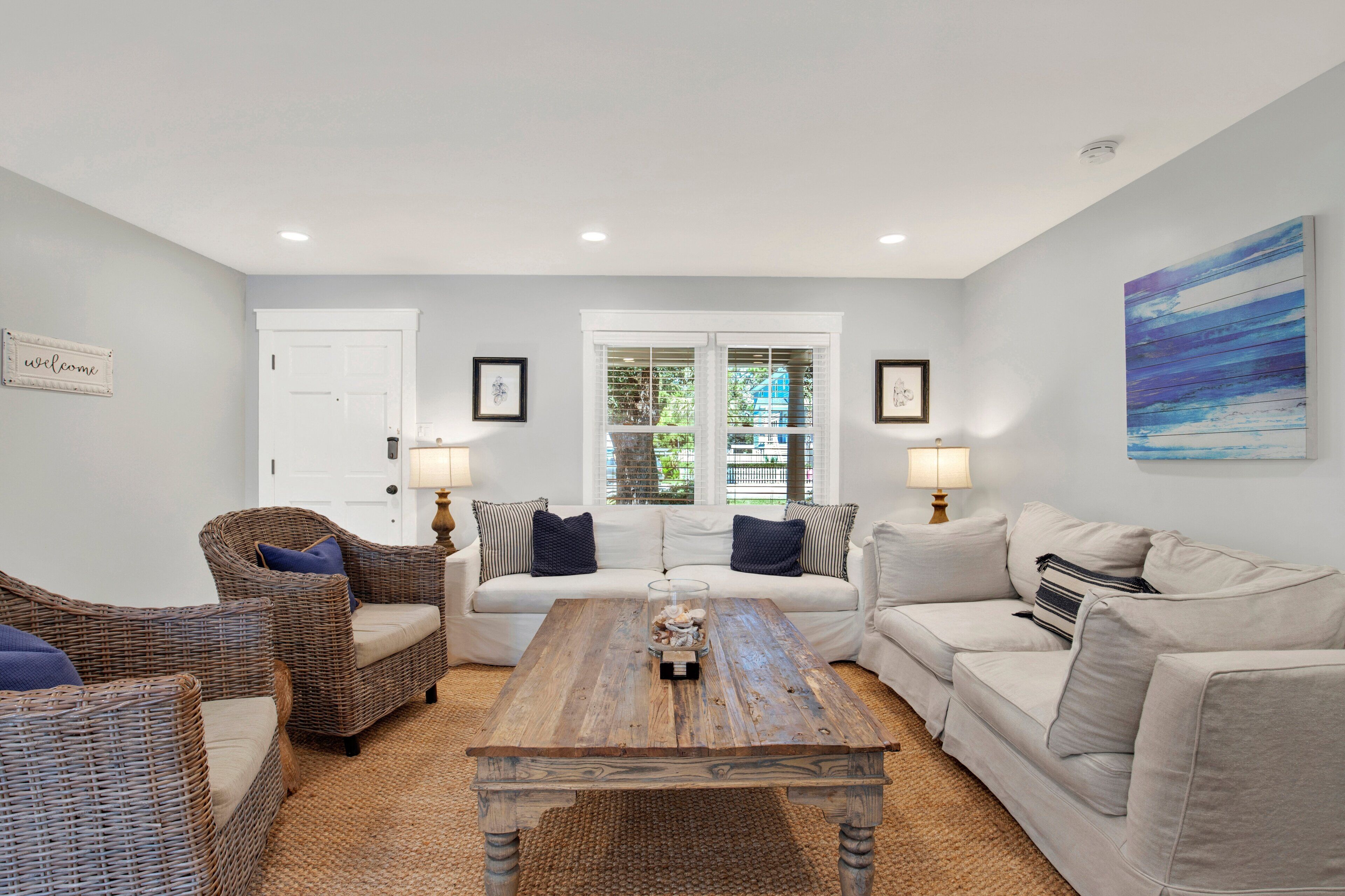 A living room with a sofa, two armchairs, a coffee table, and a painting on the wall.