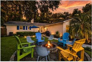 A backyard with a fire pit, outdoor seating, and a house. - Private Heated Pool, Family Beach Getaway (Tybee Island)