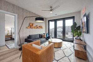 Una sala de estar moderna con un sofá, una mesa de centro y un ventanal grande.