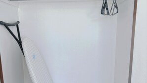 A white wall with a metal ironing board leaning against it. - Comfortable stay for 6 / Perfect for family trip (Lower Hutt)