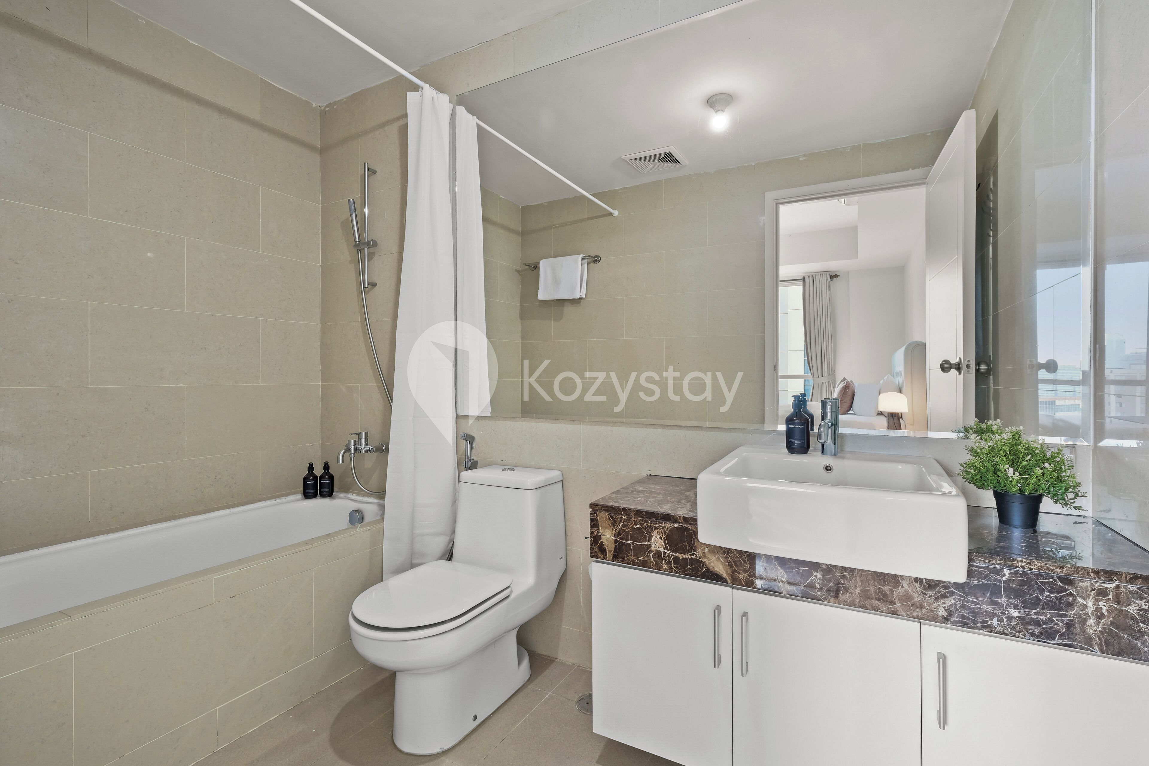 A modern bathroom with a bathtub, toilet, and sink.