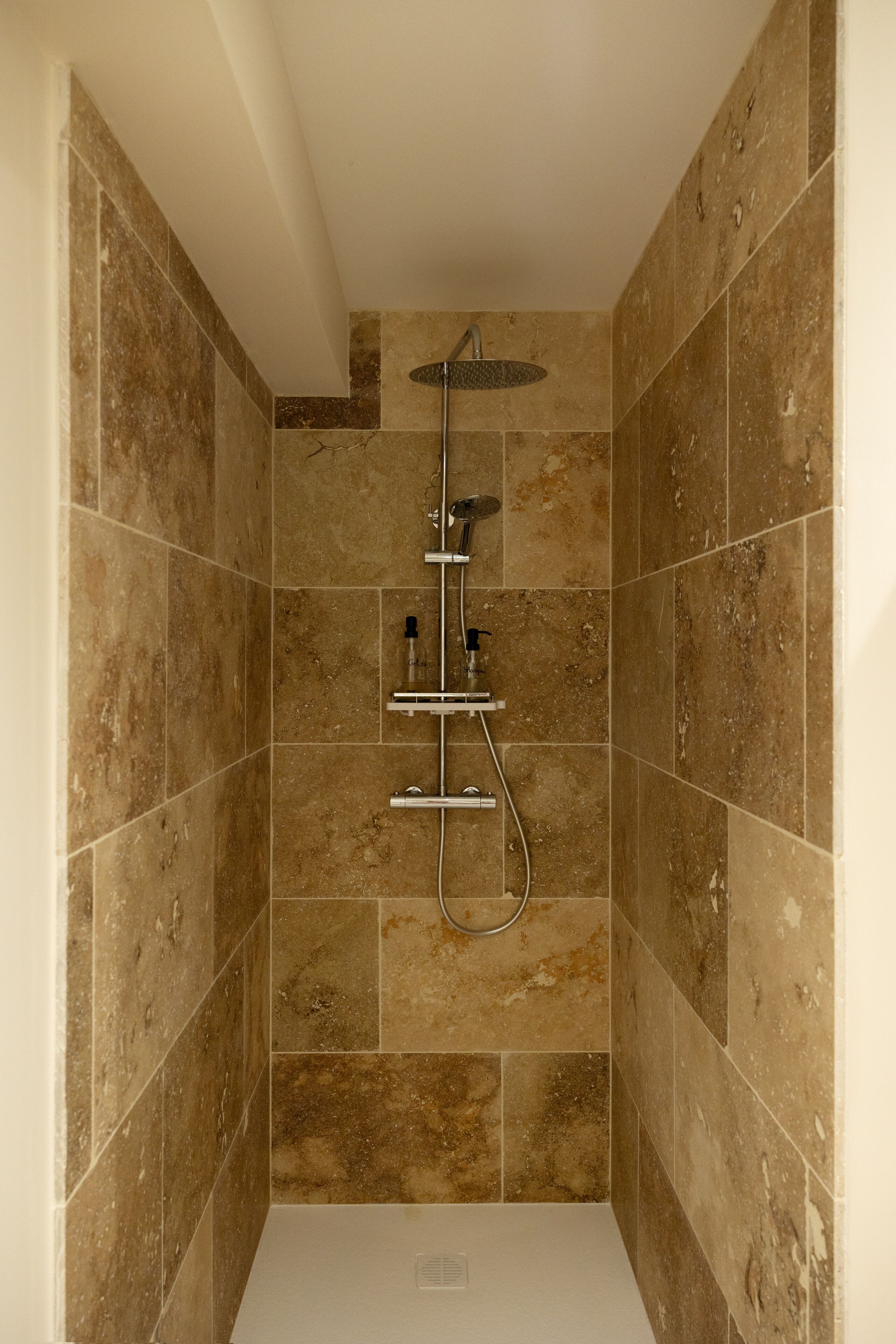 Een douche met een handdouche en een wanddouche.